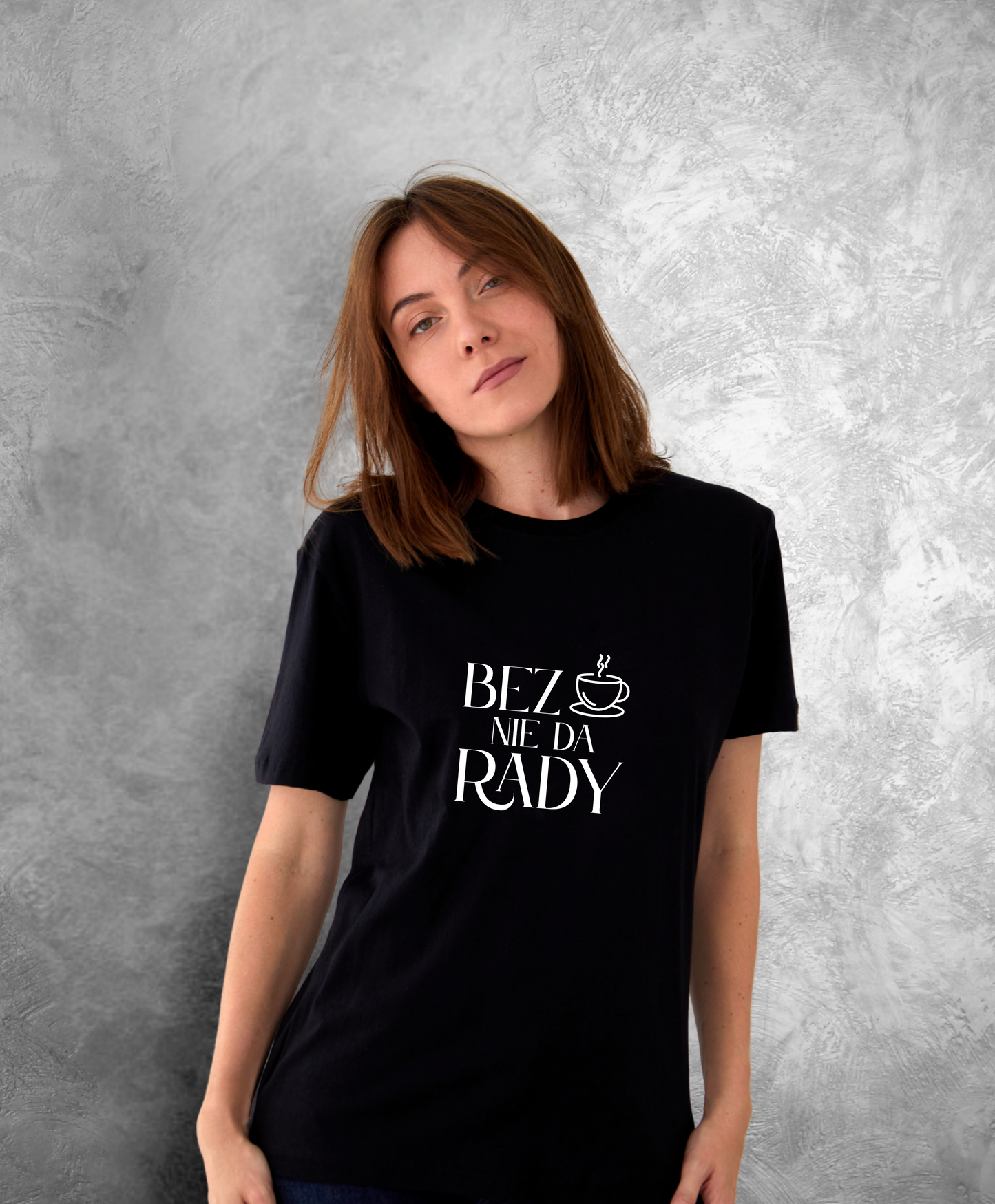 Zdjęcie przedstawia uśmiechniętą kobietę w czarnej koszulce z napisem "Bez kawy nie da rady".