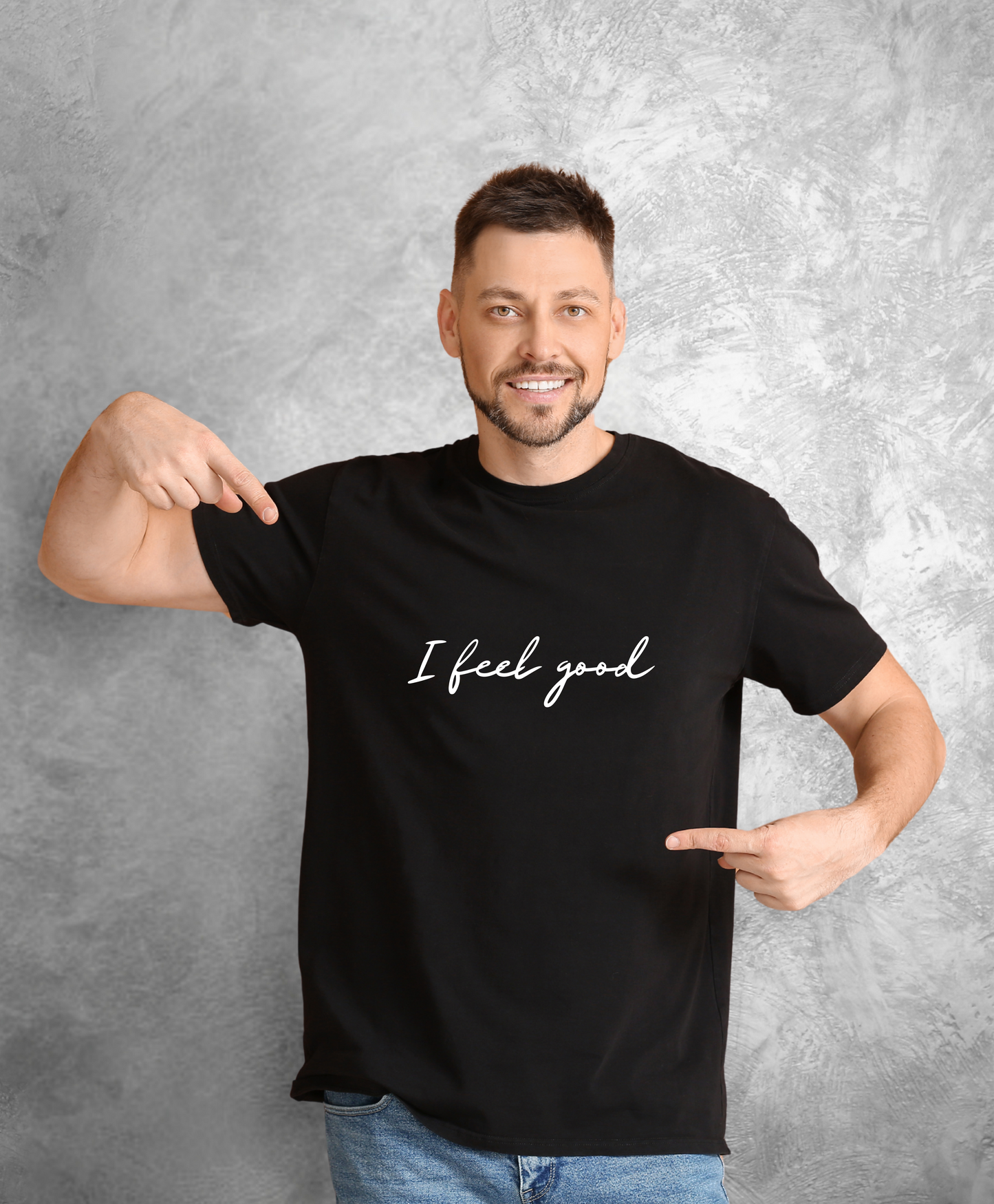 Pozujący do kamery, uśmiechnięty mężczyzna stojący przodem do kamery ubrany w czarny t-shirt z białym napisem "I feel good"
