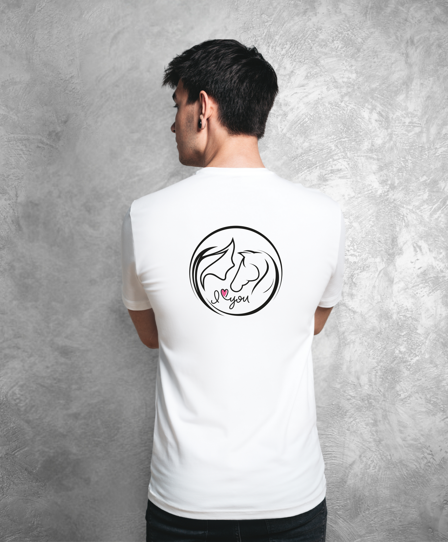 Zdjęcie przedstawia mężczyznę stojącego tyłem do kamery. Ubrany jest w biały t-shirt z nadrukiem na plecach. Nadruk przedstawia koło z graficznie pokazaną głową kobiety i konia z profilu oraz napis I love you, gdzie słowo "love" przedstawione jest jako różowe serce. Reszta nadruku jest w kolorze czarnym.