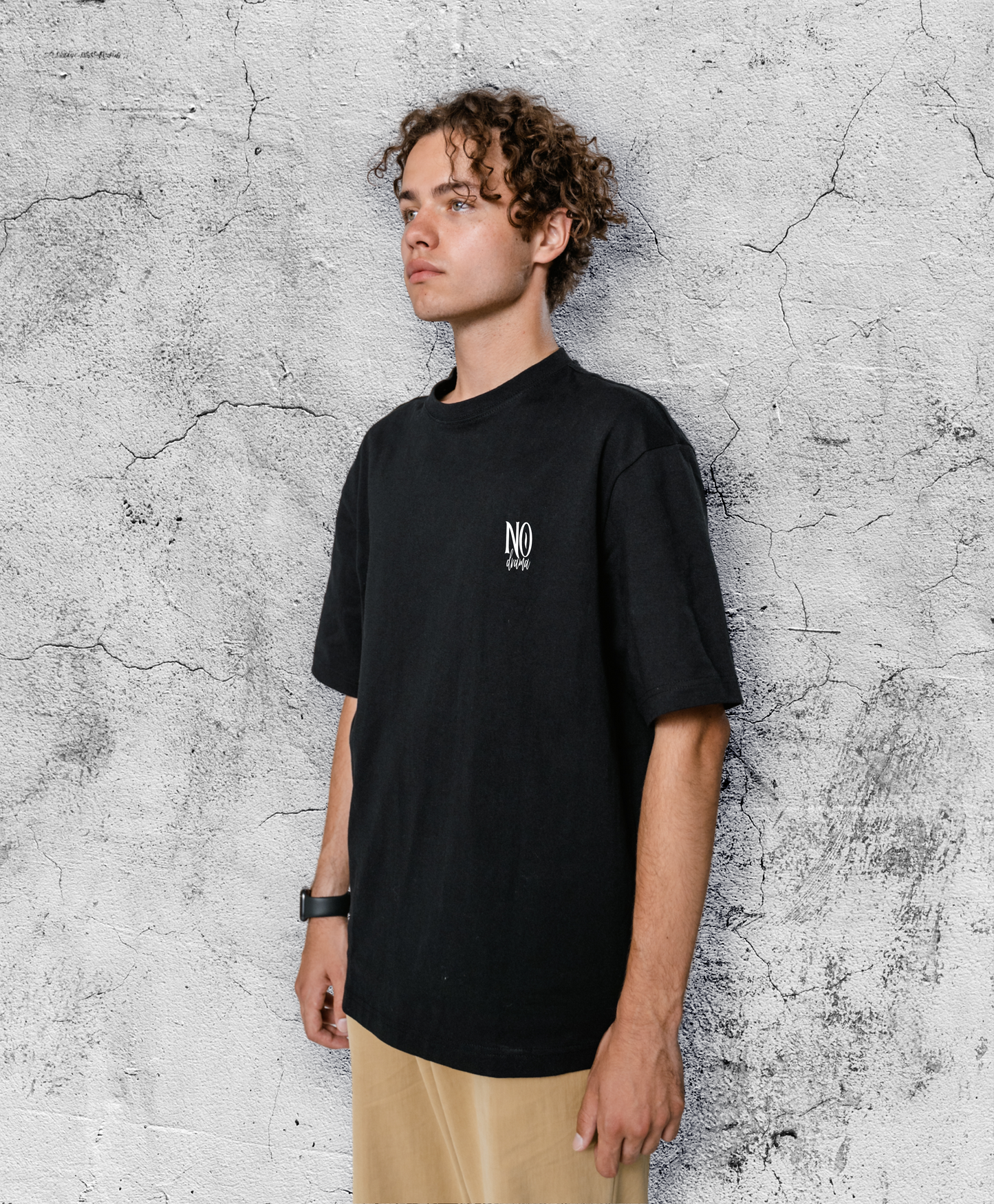 Mężczyzna w czarnym t-shircie z biały małym białym napisem "No drama"