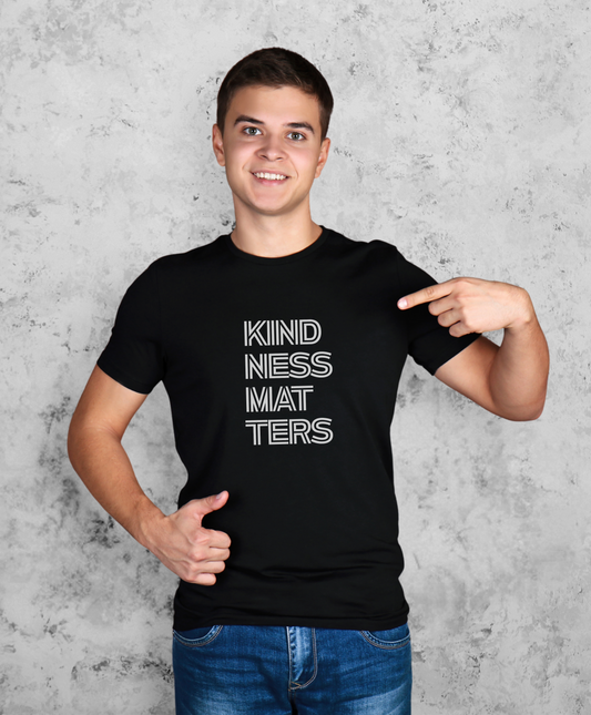 Mężczyzna stojący przodem do kamery. Ma na sobie czarną koszulkę z białym napisem "Kindness matters"