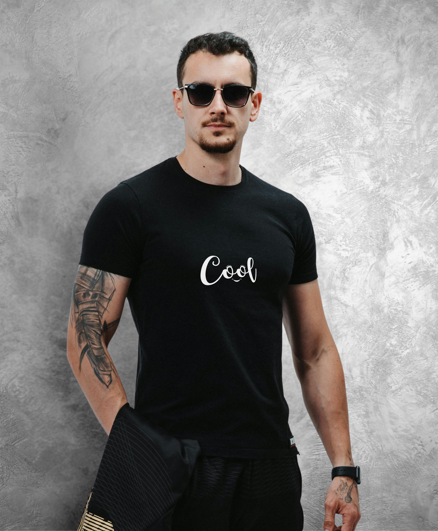 mężczyzna w ciemnych okularach przeciwsłonecznych w czarnym t-shircie z białym napisem "Cool"
