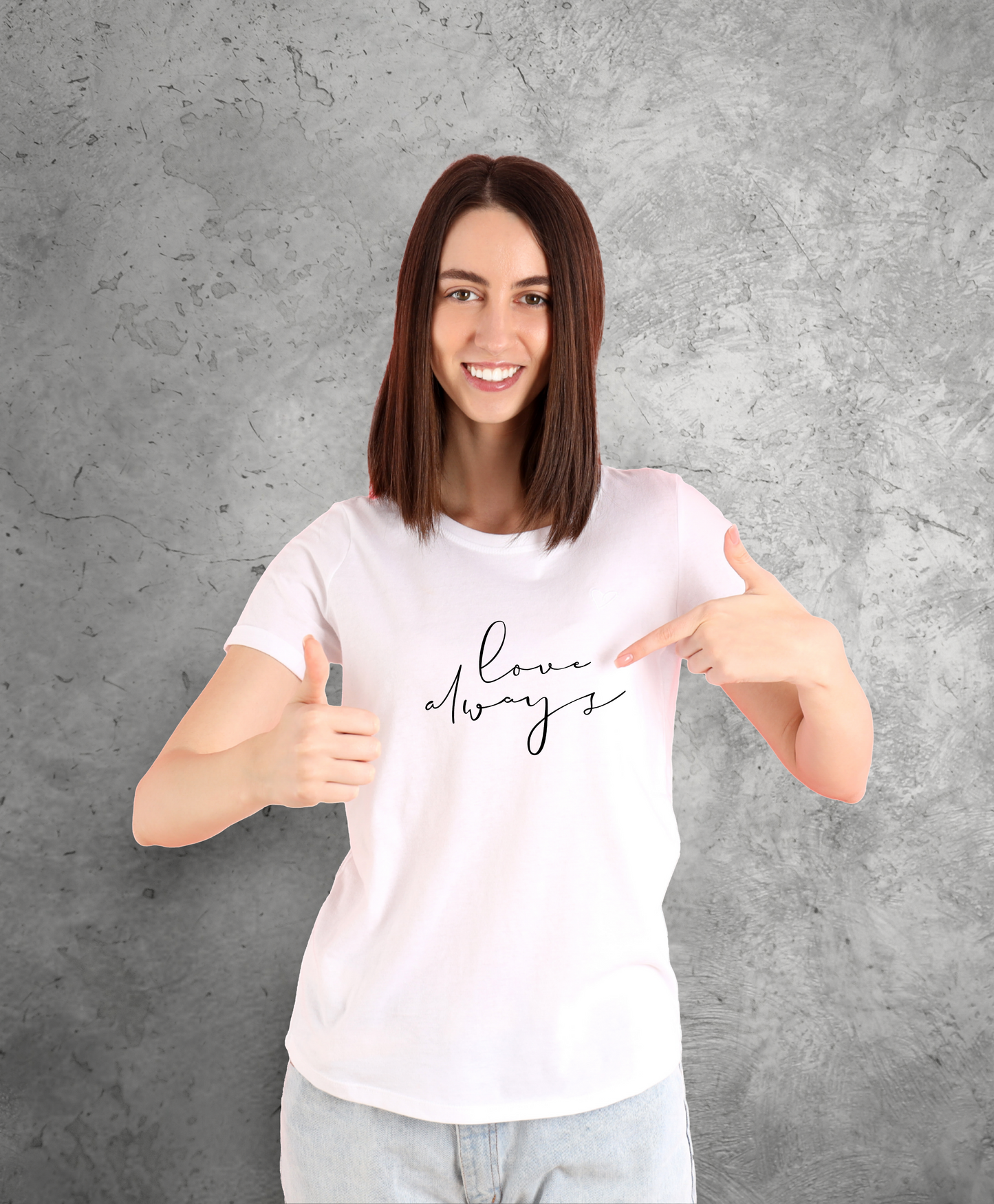Uśmiechnięta kobieta stojąca przodem do kamery, ubrana w biały t-shirt z czarnym napisem "Love always"