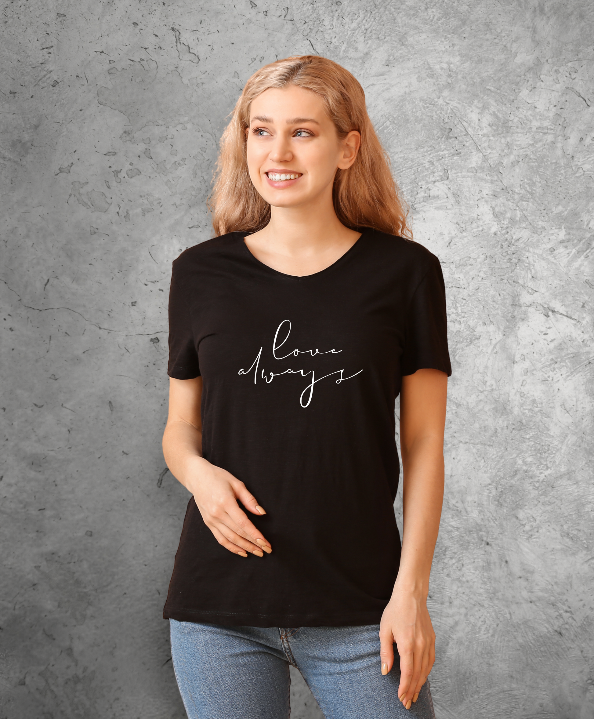 Uśmiechnięta kobieta stojąca przodem do kamery, ubrana w czarny t-shirt z białym napisem "Love always"