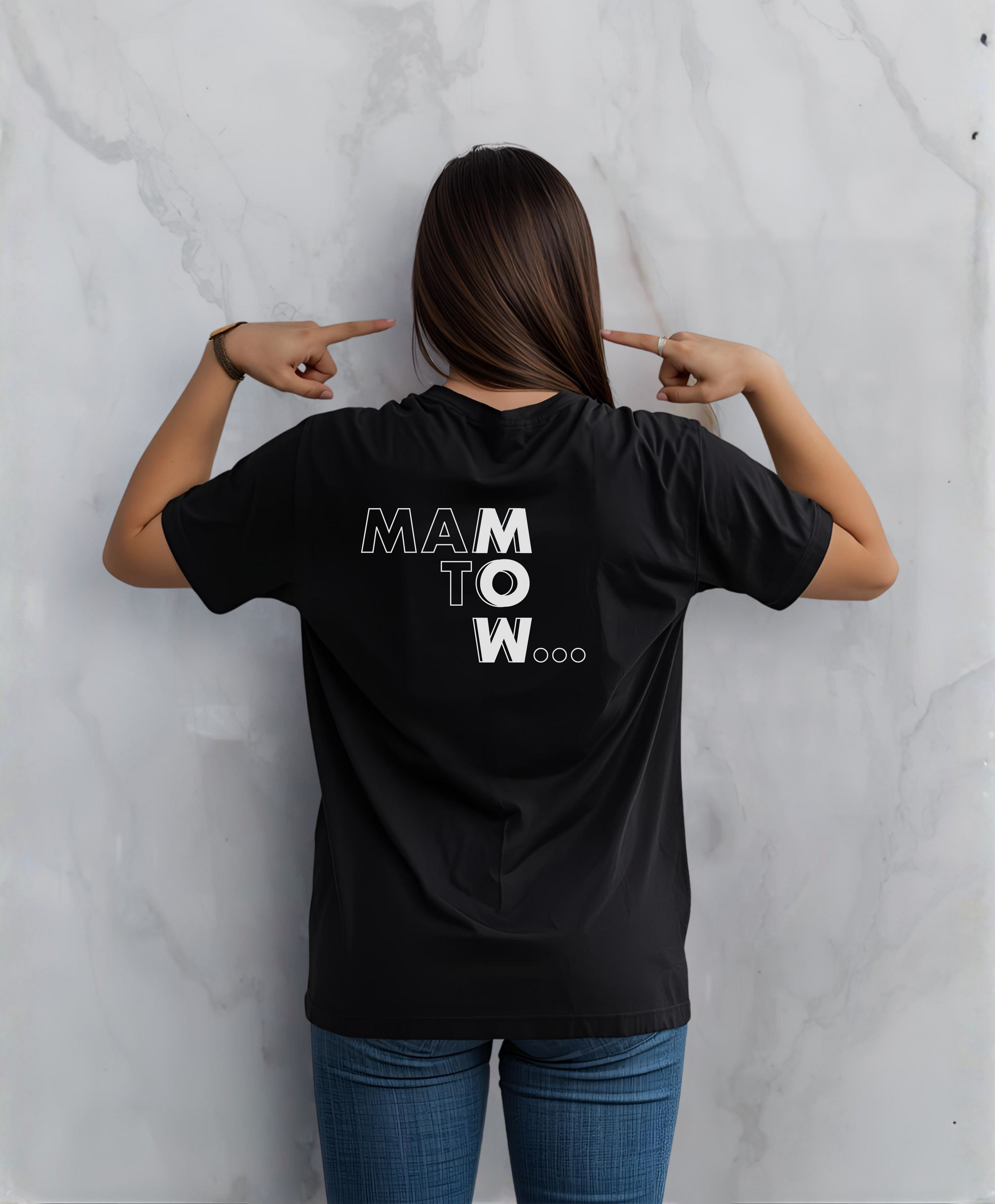 Kobieta stojąca tyłem do kamery. Ubrana w czarny t-shircie z białym napisem "Mam to w..."