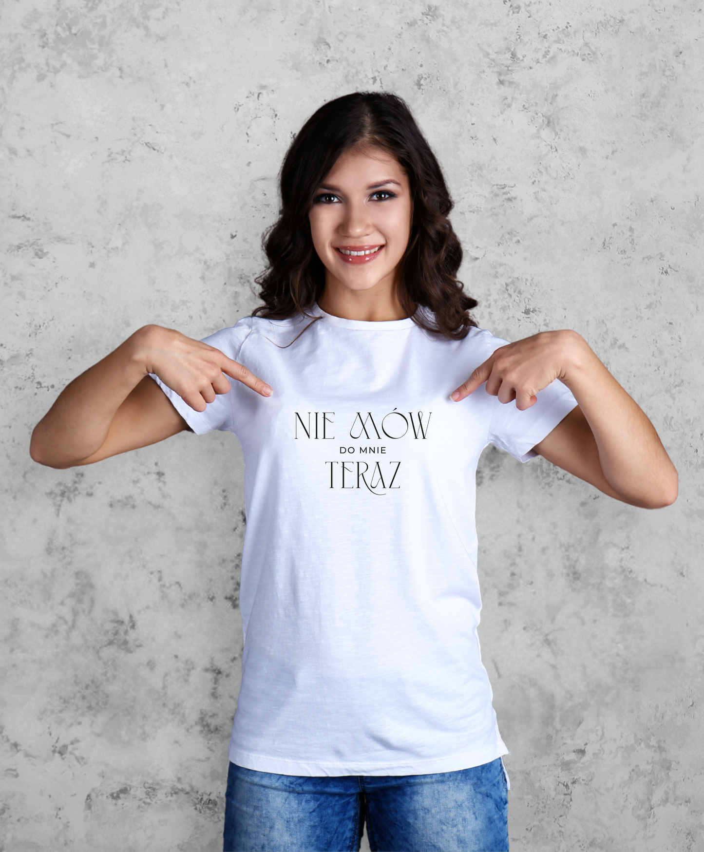 Zdjęcie przedstawia uśmiechniętą kobietę w białej koszulce z czarnym napisem "Nie mów do mnie teraz". 