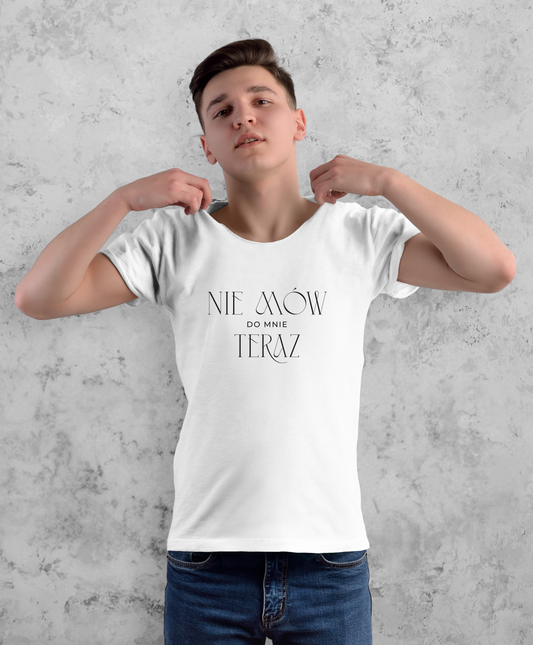 Zdjęcie przedstawia mężczyznę  w białej koszulce z czarnym napisem "Nie mów do mnie teraz". 