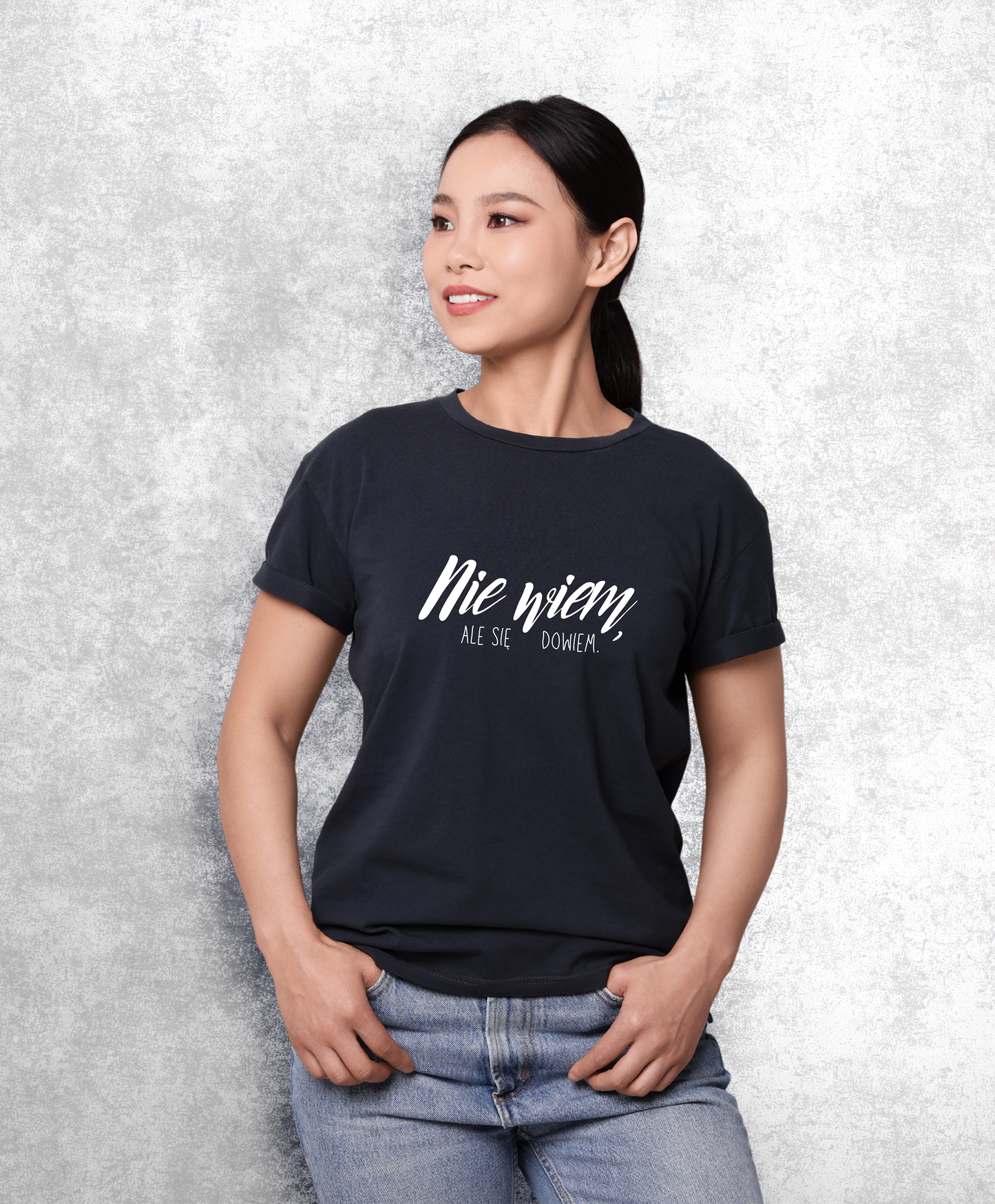 Uśmiechnięta kobieta w czarnym t-shircie z białym napisem "Nie wiem, ale się dowiem"