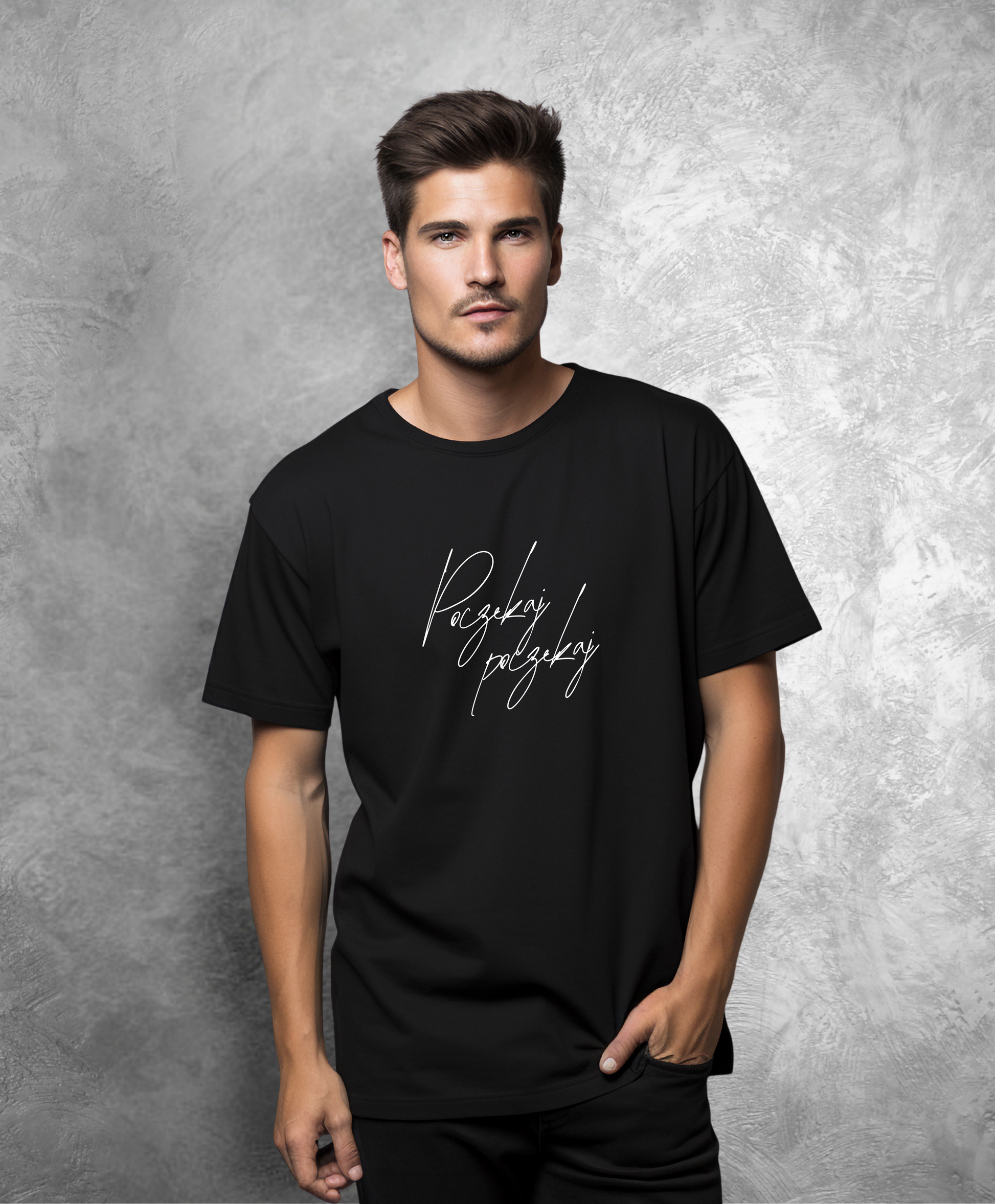 Zdjęcie przedstawia mężczyznę stojącego przodem do kamery. Ma na sobie czarną koszulkę z białym napisem "Poczekaj, poczekaj"  