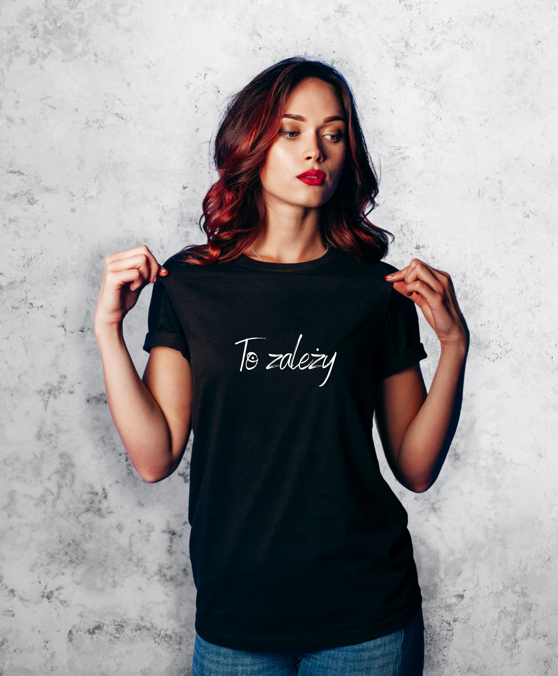 Zdjęcie przedstawia kobietę, stojącą przodem do kamery, ubraną w czarną koszulkę z białym napisem na przodzie "To zależy"