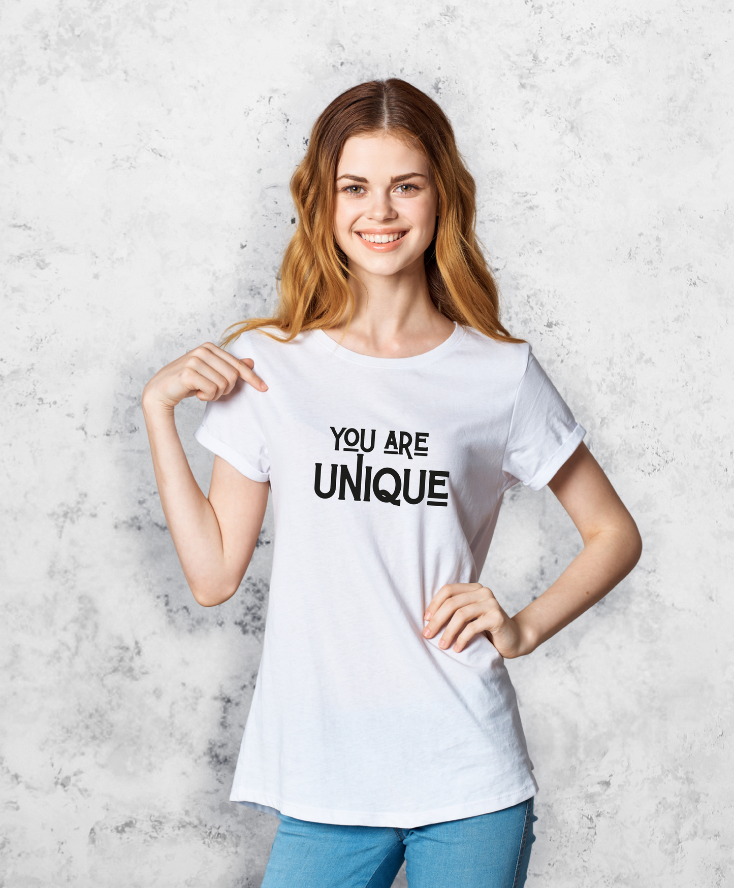 Zdjęcie przedstawia uśmiechniętą kobietę białej koszulce z napisem "You are unique".