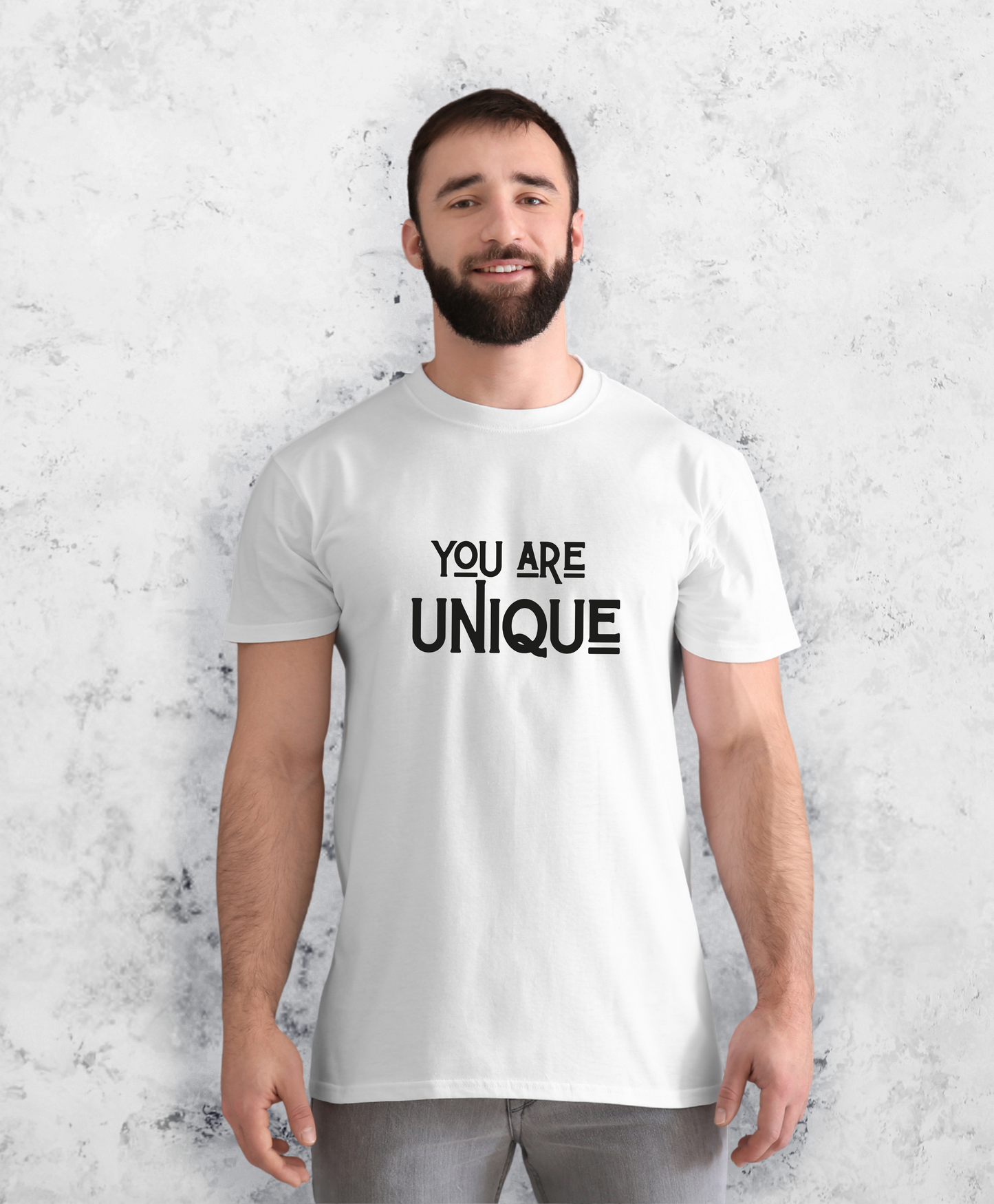 Zdjęcie przedstawia mężczyznę w białej koszulce z napisem "You are unique"