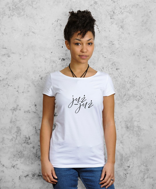 Kobietę stojąca przodem do kamery, ubrana w białą koszulkę z czarnym napisem "już-już".  