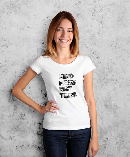 Kobieta stojąca przodem do kamery. Ma na sobie białą koszulkę z czarnym napisem "Kindness matters"