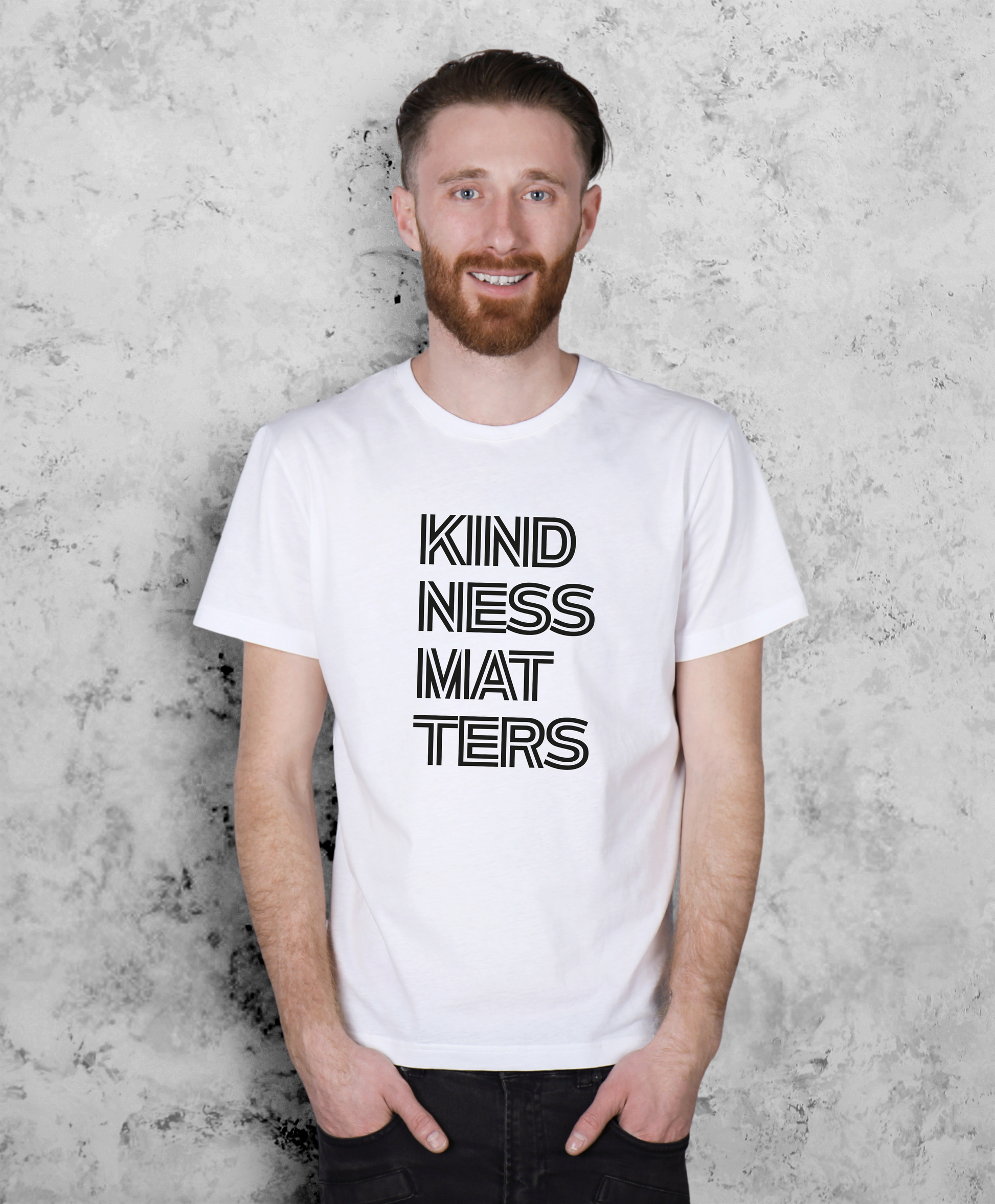Mężczyzna stojący przodem do kamery. Ma na sobie białą koszulkę z czarnym napisem "Kindness matters"