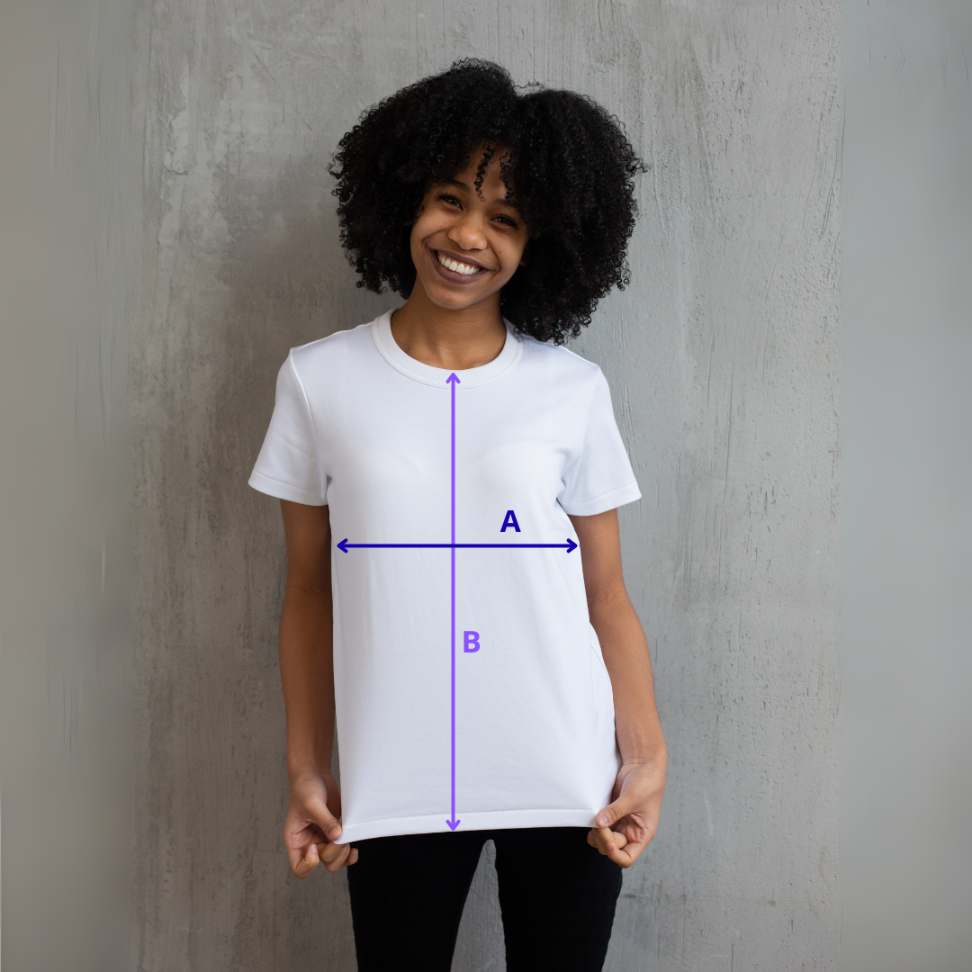 zdjęcie przedstawia uśmiechniętą kobietę stojącą na szarym tle, w białej koszulce, na której narysowane są strzałki z literami. Strzałka z literą A oznacza szerokość koszulki, strzałka z literą B oznacza długość koszulki