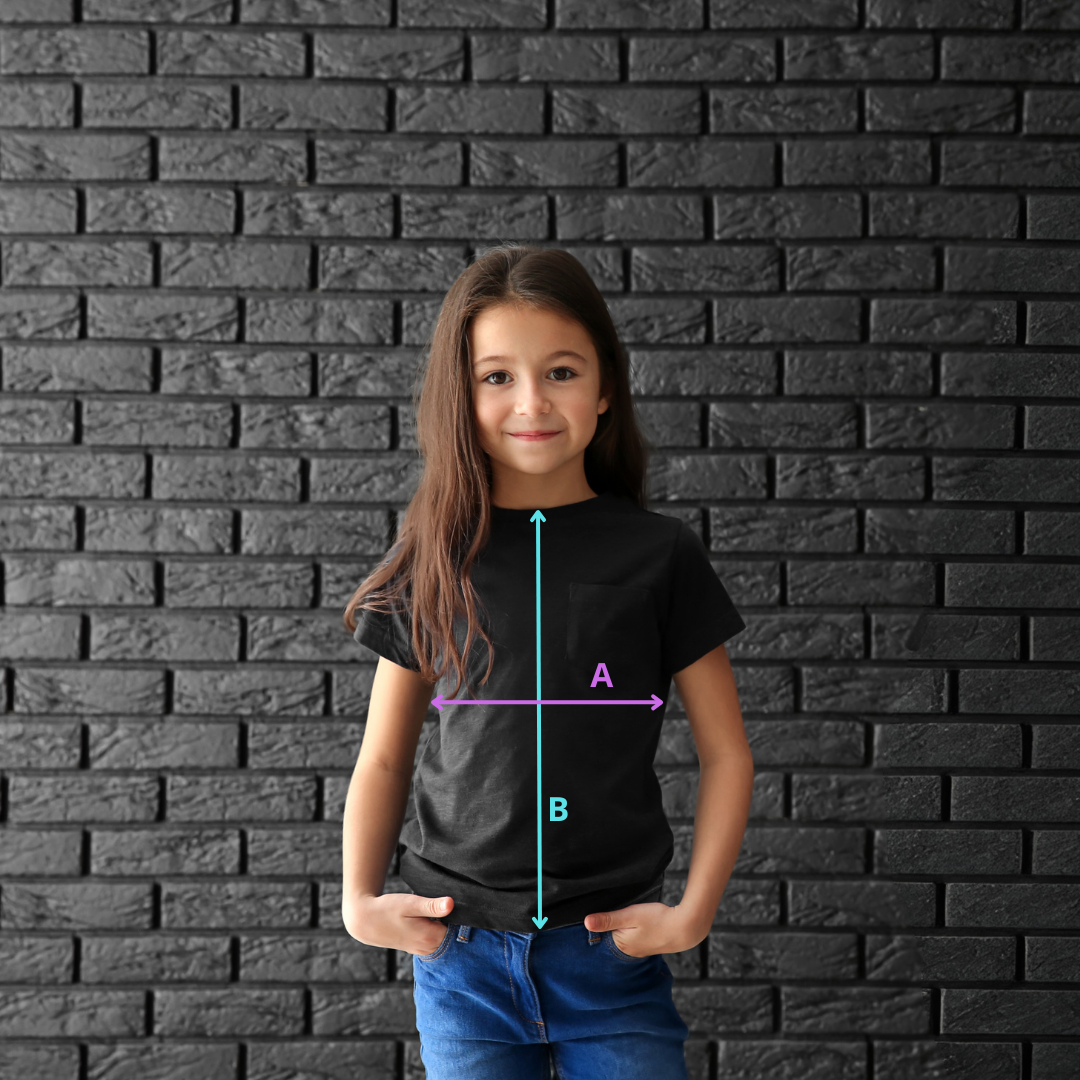 zdjęcie przedstawia uśmiechniętą dziewczynkę stojącą na tle czarnej ceglanej ściany. Ubrana jest w czarną koszulkę, na której narysowane są strzałki z literami. Strzałka z literą A oznacza szerokość koszulki, strzałka z literą B oznacza długość koszulki
